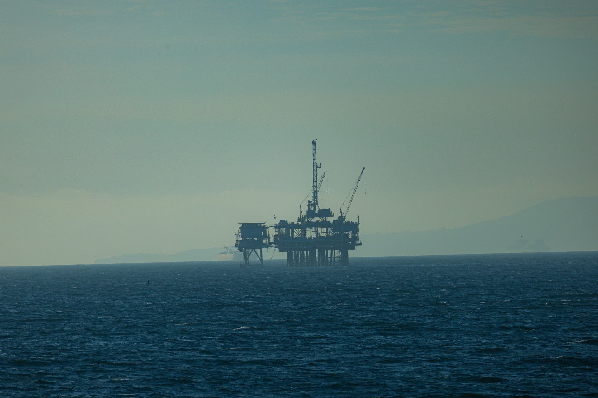 Offshore oil platform on the horizon at sea